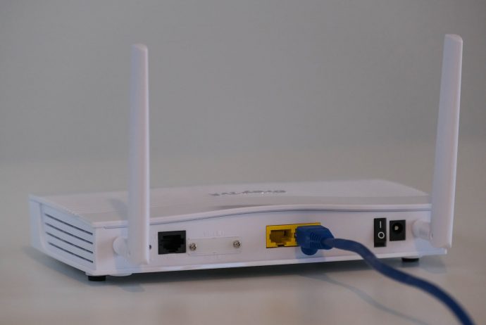A white router with antennas and LED lights indicating connectivity.