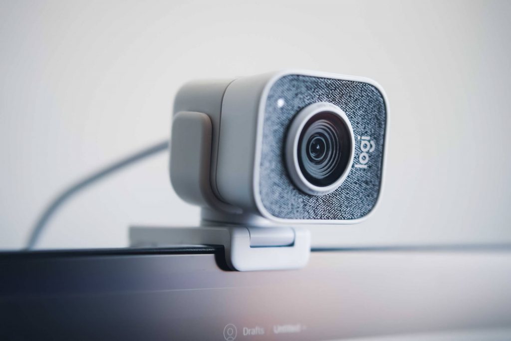 A webcam placed on top of a computer screen, ready for video calls or recordings.
